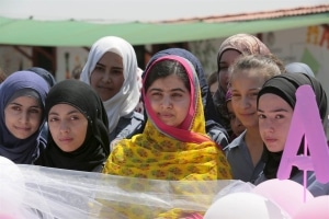Malala Yousafzai, center, poses with girls for a picture at a school for Syrian refugee girls in Lebanon's Bekaa Valley on July 12. The Malala Fund, a non-profit organisation that supports local education projects, paid for the school in the Bekaa Valley, close to the Syrian border. JAMAL SAIDI / Reuters