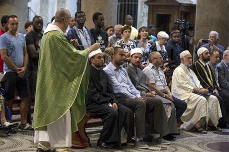 Muslims attend a Mass in Rome's Saint Mary in Trastevere church, Italy, Sunday, July 31, 2016. Imams and practicing Muslims attended Mass across Italy, from Palermo in the south to Milan in the north, in a sign of solidarity after the France church attack in which an elderly priest was slain. (Massimo Percossi/Ansa via AP)